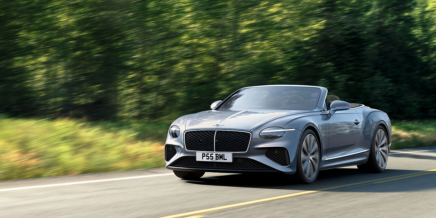 Bentley Macau New Bentley Continental GTC convertible front view in Silverlake paint with 22 inch ten spoke wheels, driving dynamically on a country road