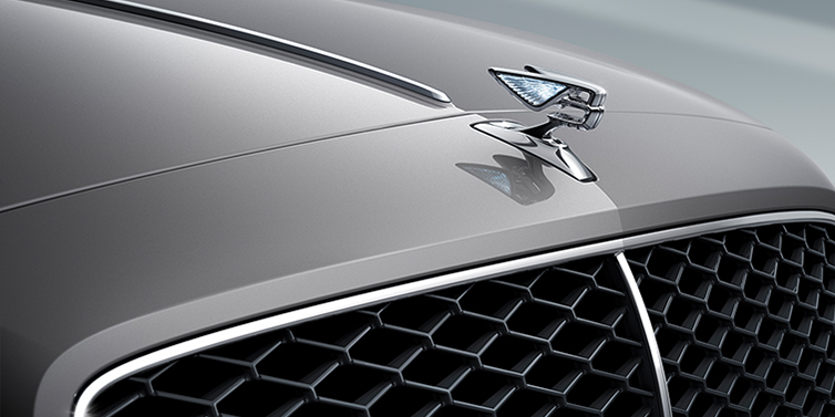Bentley Macau New Bentley Flying Spur sedan bonnet detail in Silverlake paint with Illuminated Flying B bonnet badge and matrix grille with chrome surround